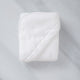 Folded Baby Hooded Towel in white, flat lay shot with marble background