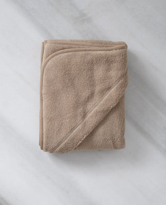 Baby Hooded Towel in color latte, detail shot from hood and DOUXE logo with marble background