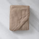 Folded Baby Hooded Towel in color latte, flat lay shot with marble background