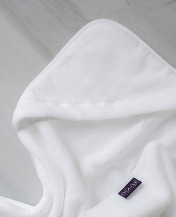 Baby Hooded Towel in white, detail shot from hood and DOUXE logo with marble background