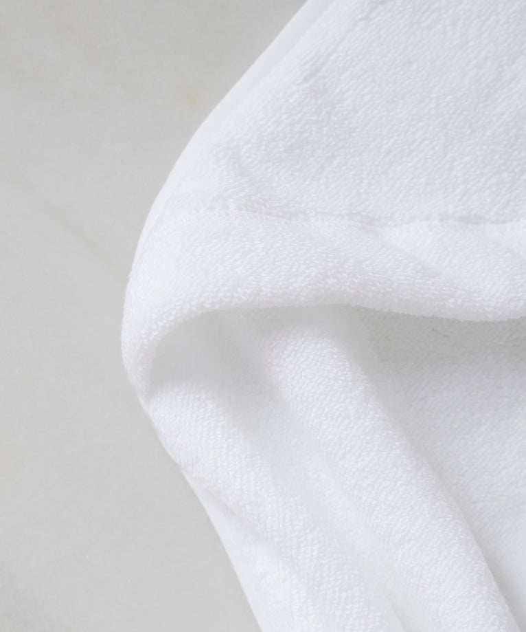 Baby hooded towel in white, detail shot from zero-twist cotton wit marble background